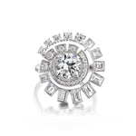Introducing the Spiral Ring in White Gold, showcasing a large round brilliant diamond at its center, surrounded by sparkling smaller round and baguette diamonds arranged in a dazzling spiral pattern that enhances the ring’s radiant brilliance.