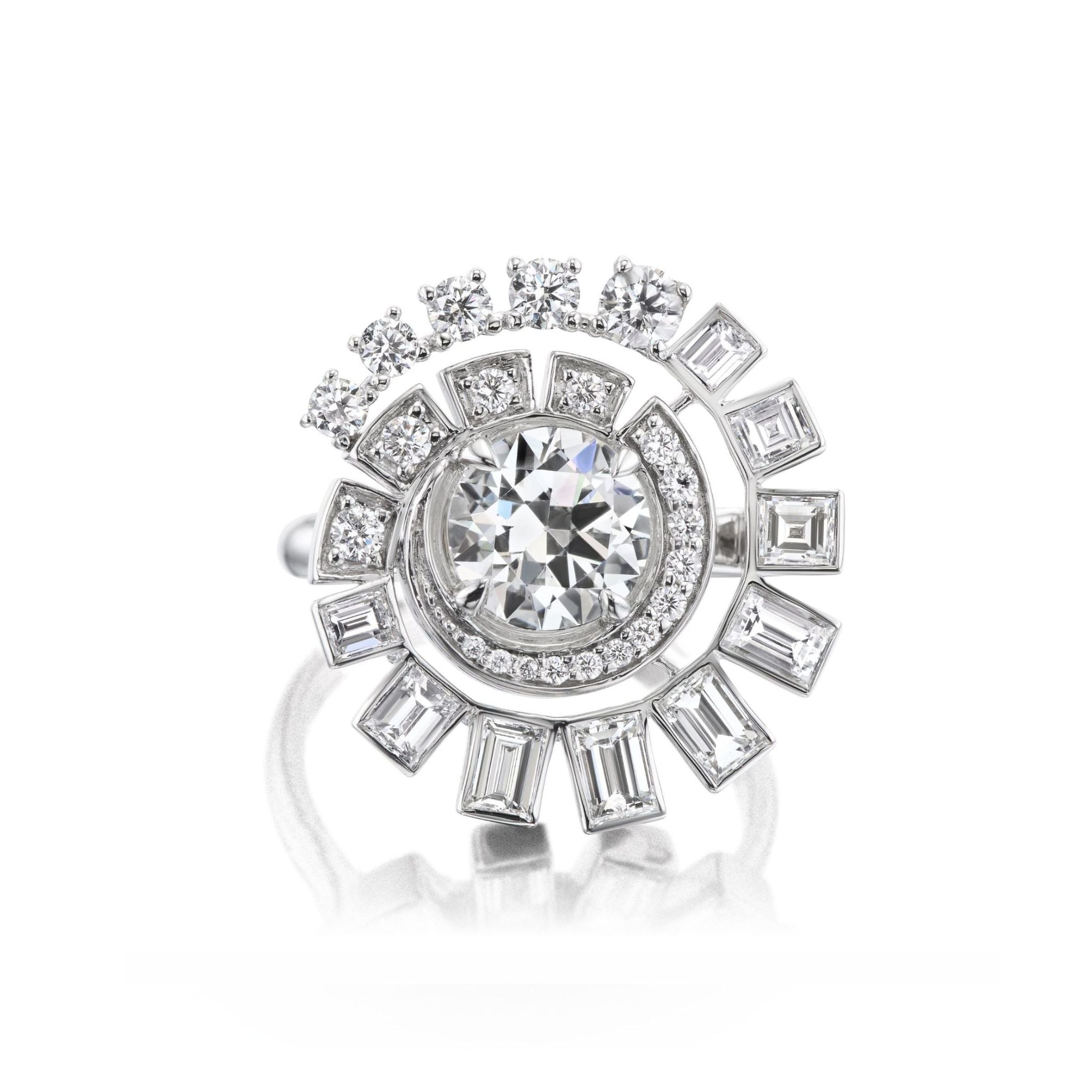 Introducing the Spiral Ring in White Gold, showcasing a large round brilliant diamond at its center, surrounded by sparkling smaller round and baguette diamonds arranged in a dazzling spiral pattern that enhances the ring’s radiant brilliance.