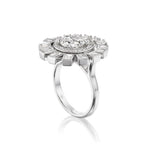 Introducing the Spiral Ring in White Gold with Round Brilliant and Baguette Diamonds—a captivating 18k white gold piece showcasing a prominent round brilliant diamond at its center, elegantly encircled by an array of smaller round brilliant and baguette diamonds arranged in a striking spiral design reminiscent of a floral or sunburst motif, set against a pristine white background.