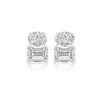 A pair of East-West Set Oval and Emerald Cut Diamond Studs in luminous 18k white gold, displayed against a crisp white background.