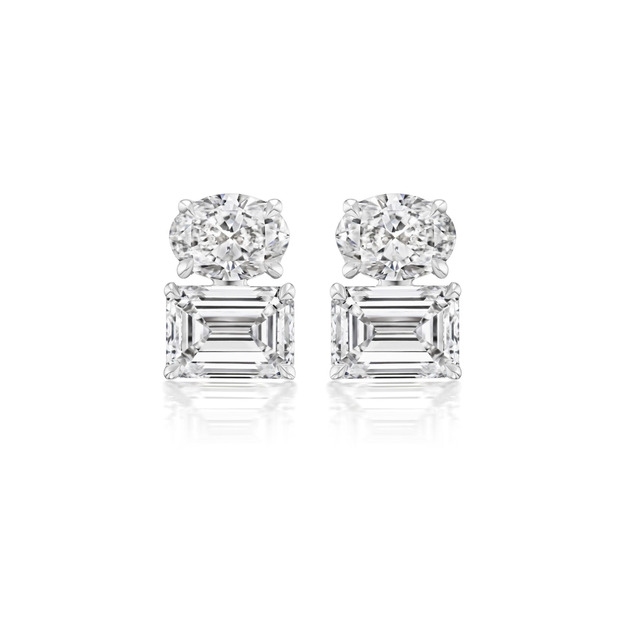 A pair of East-West Set Oval and Emerald Cut Diamond Studs in luminous 18k white gold, displayed against a crisp white background.