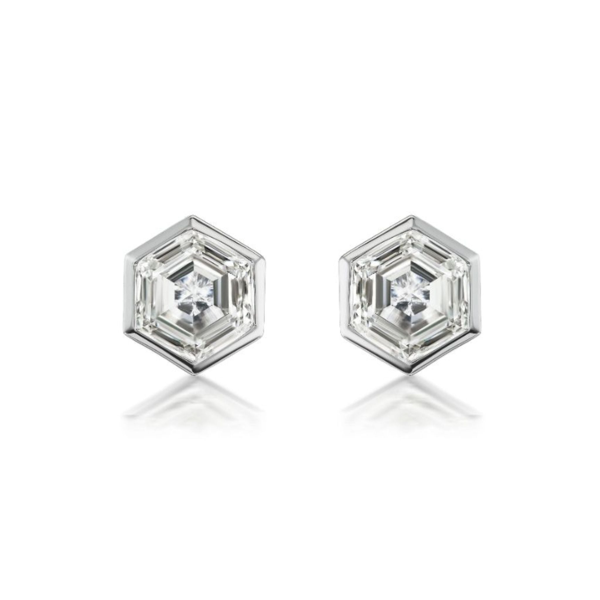 Here is a rewritten sentence using the provided product data: The Hexagonal Diamond Studs showcase a central gemstone of VS2 clarity, set in radiant 18k white gold, elegantly displayed on a white background.