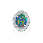 Introducing the 1980s Opal and Diamond Ring: a platinum silver statement piece showcasing a large round opal with vibrant blue, green, and orange hues, encircled by a halo of baguette-cut clear diamonds for an exceptionally stunning design.