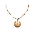 Antique Gold Watch Chain and Victorian Locket featuring a round antique pendant engraved with star patterns, displayed against a plain white background.