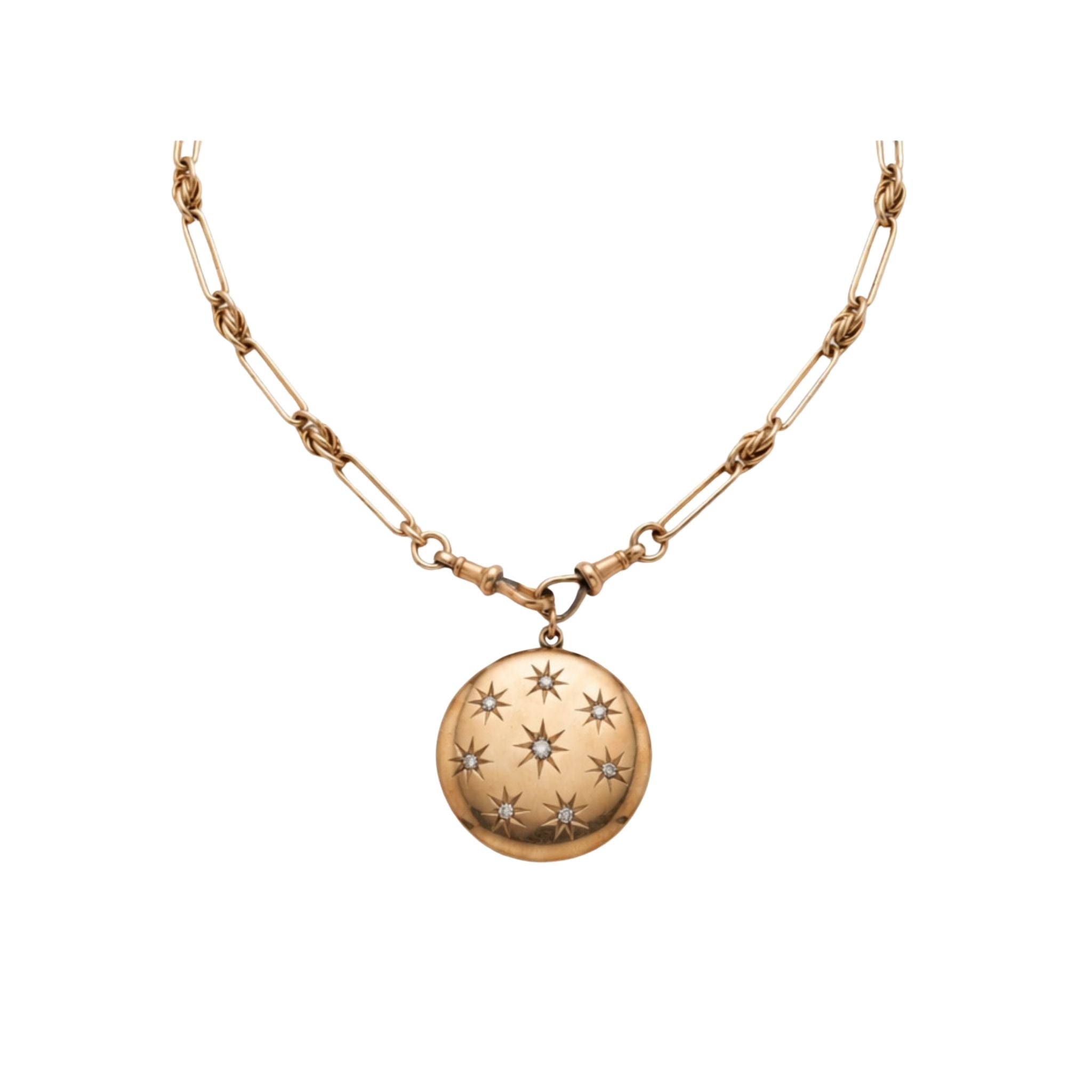 Antique Gold Watch Chain and Victorian Locket featuring a round antique pendant engraved with star patterns, displayed against a plain white background.