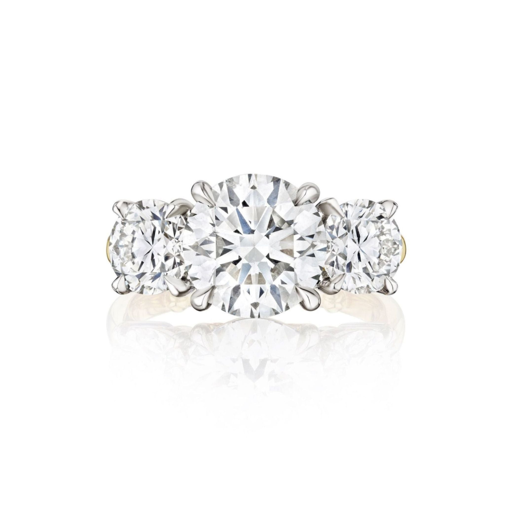 A close-up of the Diamond Engagement Ring with Round Side Stones in Platinum and Yellow Gold, showcasing a dazzling round center diamond accented by two smaller round diamonds, all set elegantly in a polished blend of platinum and yellow gold.