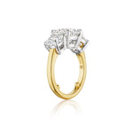 A Diamond Engagement Ring with Round Side Stones in Platinum and Yellow Gold—featuring a raised platinum setting atop a yellow gold band, set with five prominent round diamonds including a stunning center stone—shown from the side on a white background.