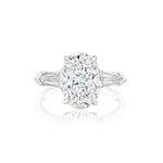 Introducing the Oval Shape Diamond Engagement Ring with Bullet Side Stones—crafted in white gold, this exquisite ring showcases a dazzling oval diamond at its center, elegantly flanked by sparkling bullet-shaped side stones. Shown against a crisp white background.