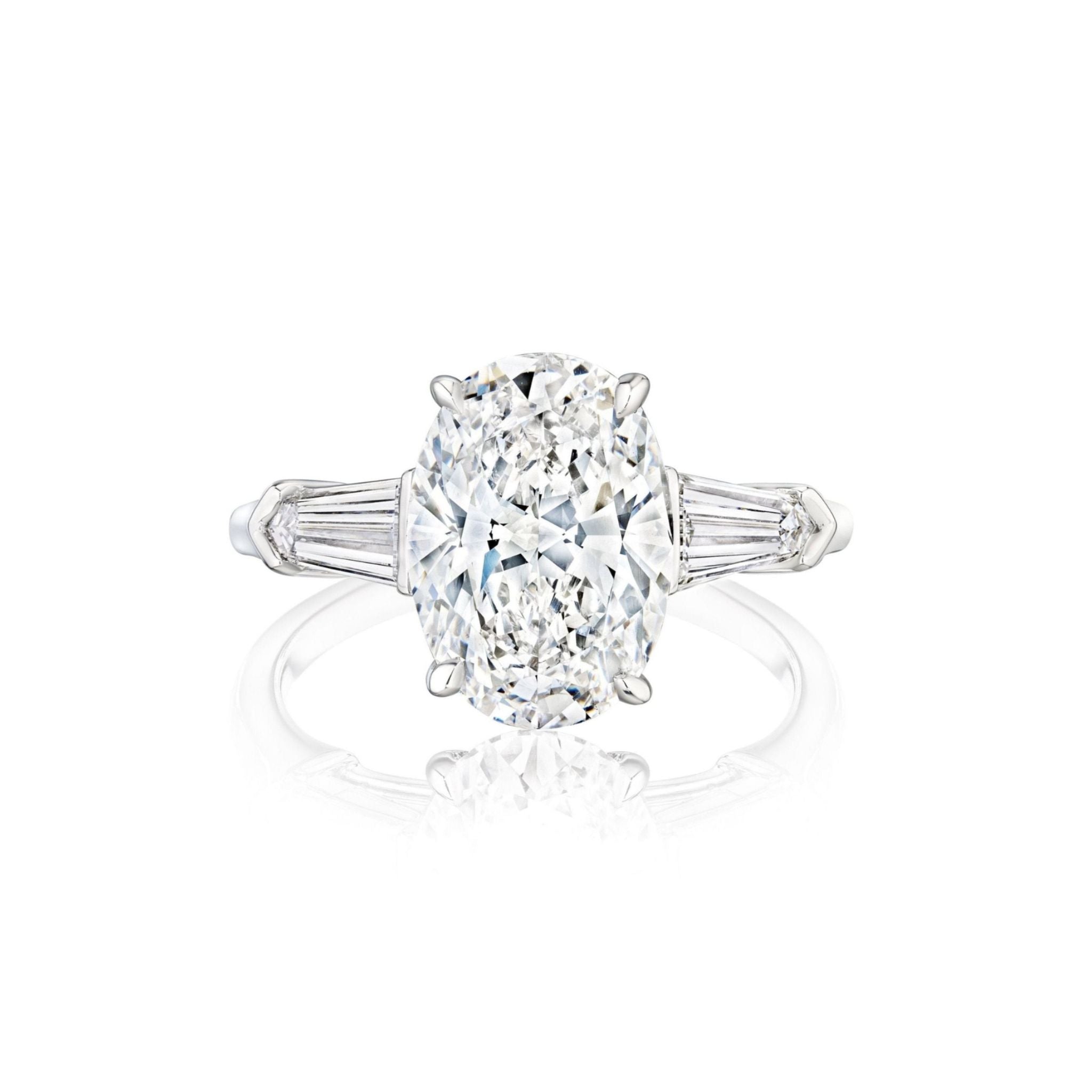 Introducing the Oval Shape Diamond Engagement Ring with Bullet Side Stones—crafted in white gold, this exquisite ring showcases a dazzling oval diamond at its center, elegantly flanked by sparkling bullet-shaped side stones. Shown against a crisp white background.