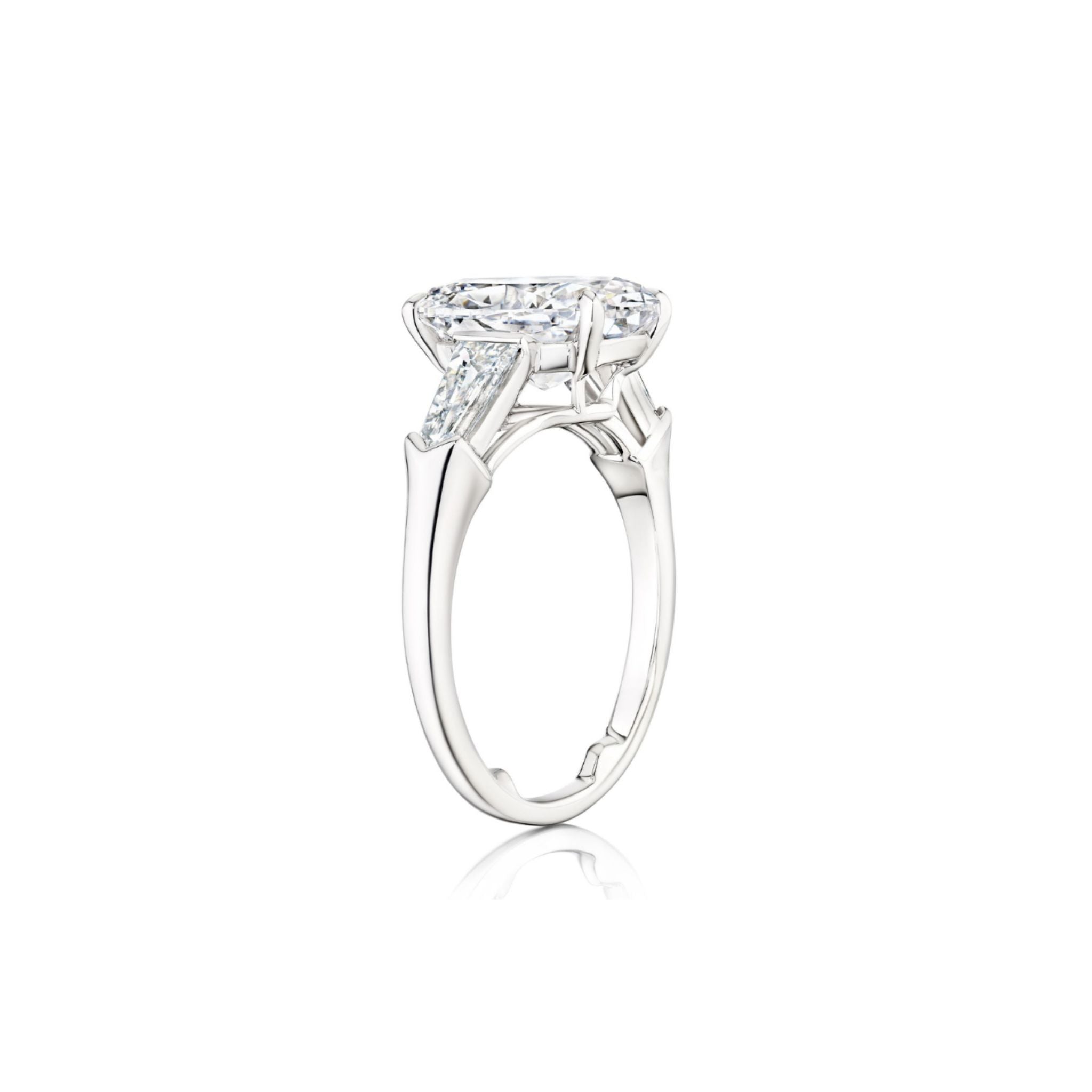 Oval Shape Diamond Engagement Ring with Bullet Side Stones, featuring a striking oval center diamond flanked by two tapered bullet-shaped side stones set on a slim, elegant platinum band, displayed from a side angle on a white background.