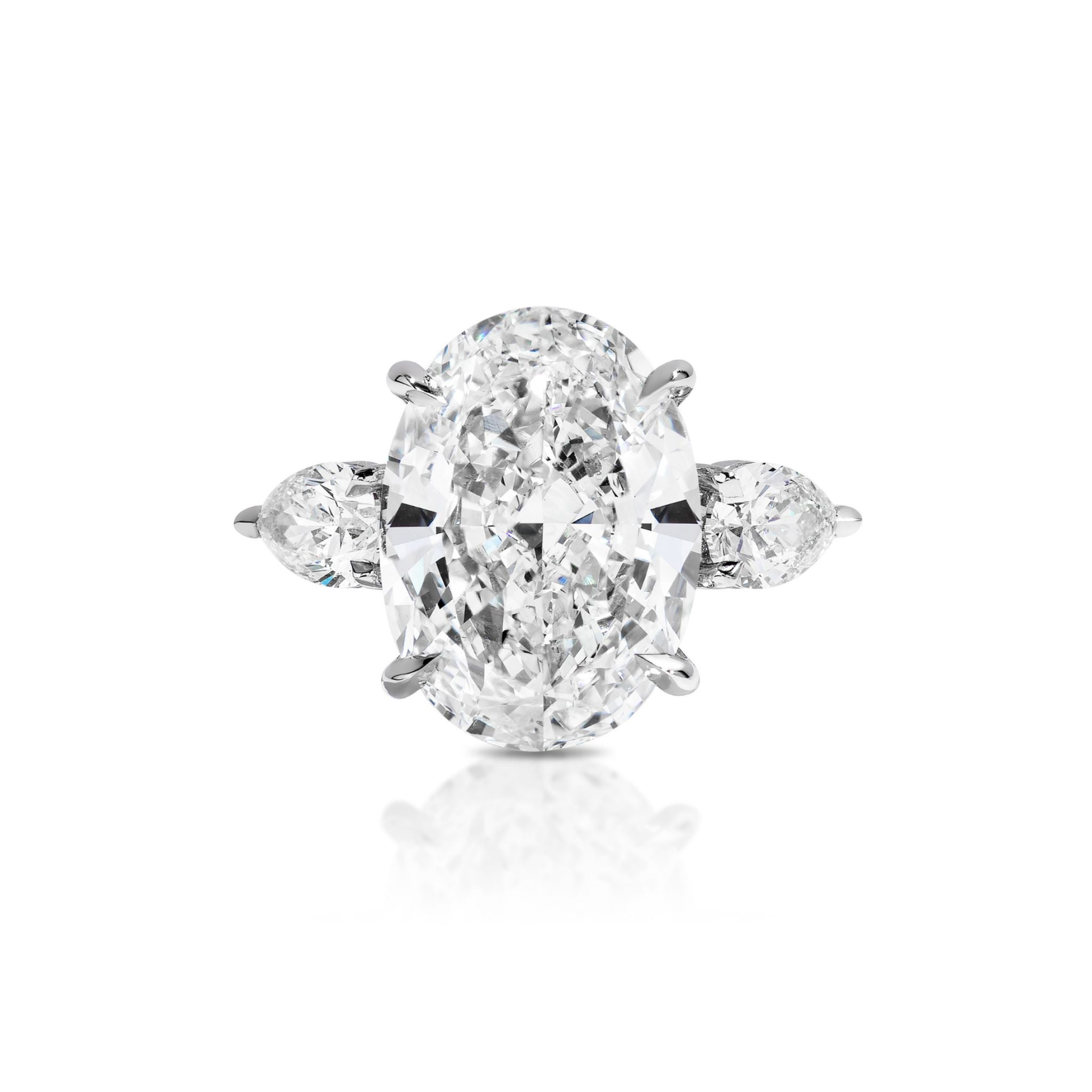 An oval-cut diamond engagement ring with two pear-shaped diamonds on each side, set in a white metal band, displayed on a white background.
