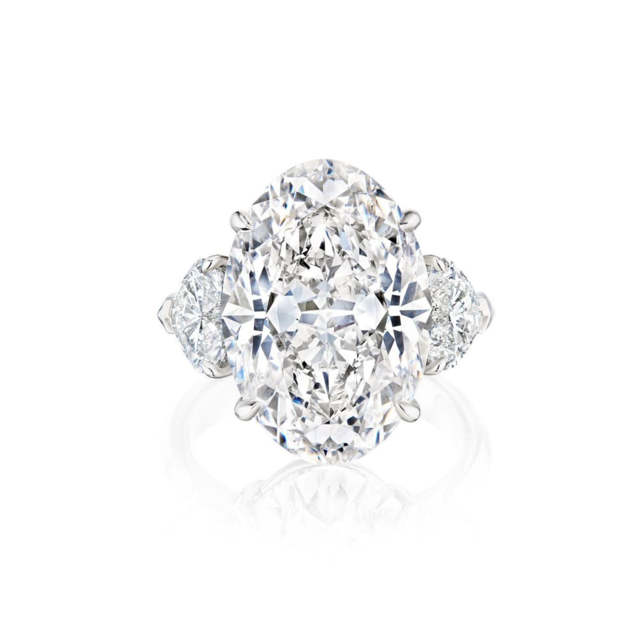 An elegant Oval Diamond Engagement Ring featuring heart-shaped side stones, set in a sleek platinum band and displayed on a white background.