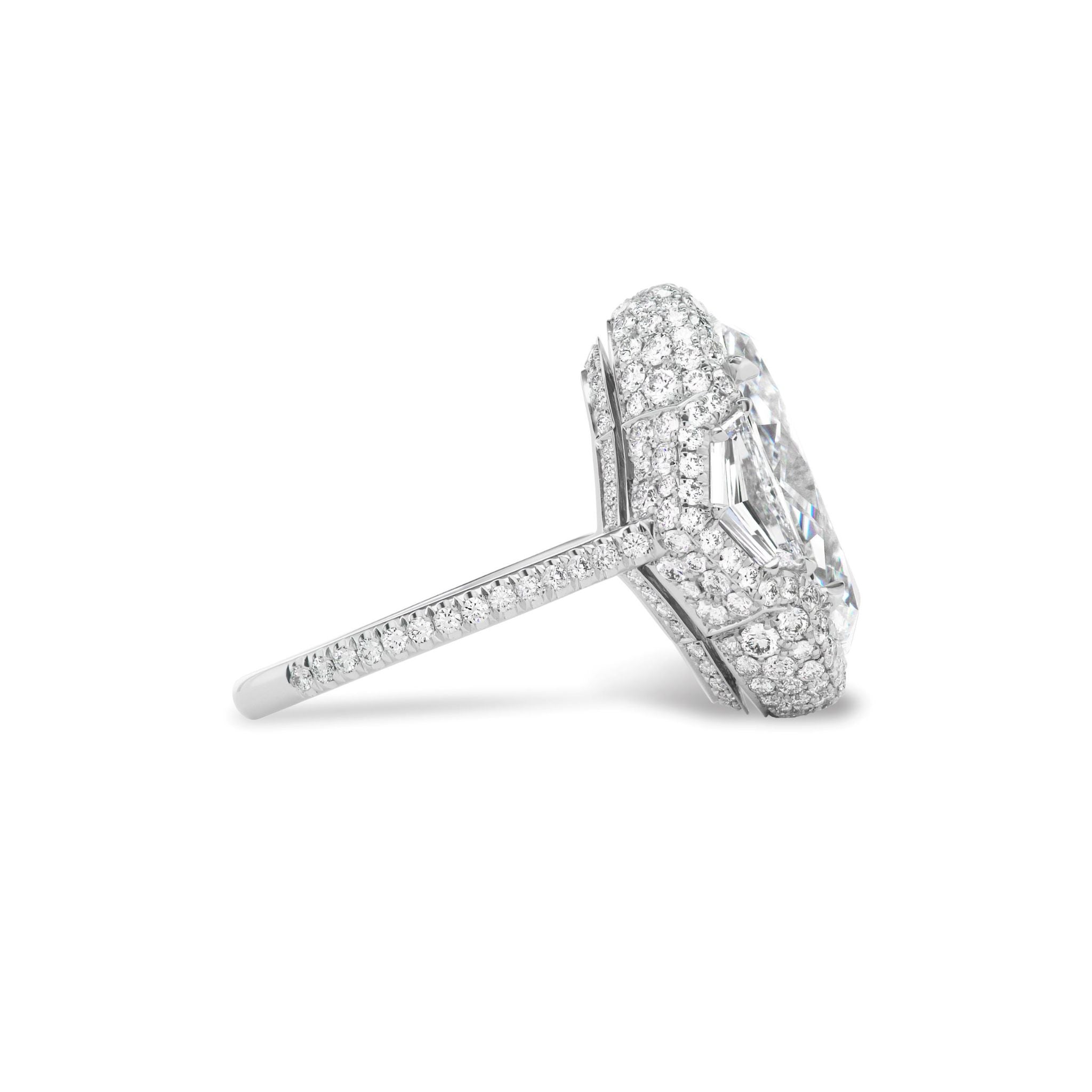 Side view of the Cobblestone Pavé Basket Ring with Oval Diamond and Epaulette Diamond Side Stones, featuring an elegant oval center stone accented by smaller diamonds set into the pavé basket setting and band, all crafted in white metal.