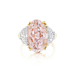The Oval Pink Diamond Engagement Ring features a captivating pink oval diamond at its center, complemented by epaulette diamond side stones, all set in an elegant platinum and yellow gold band.