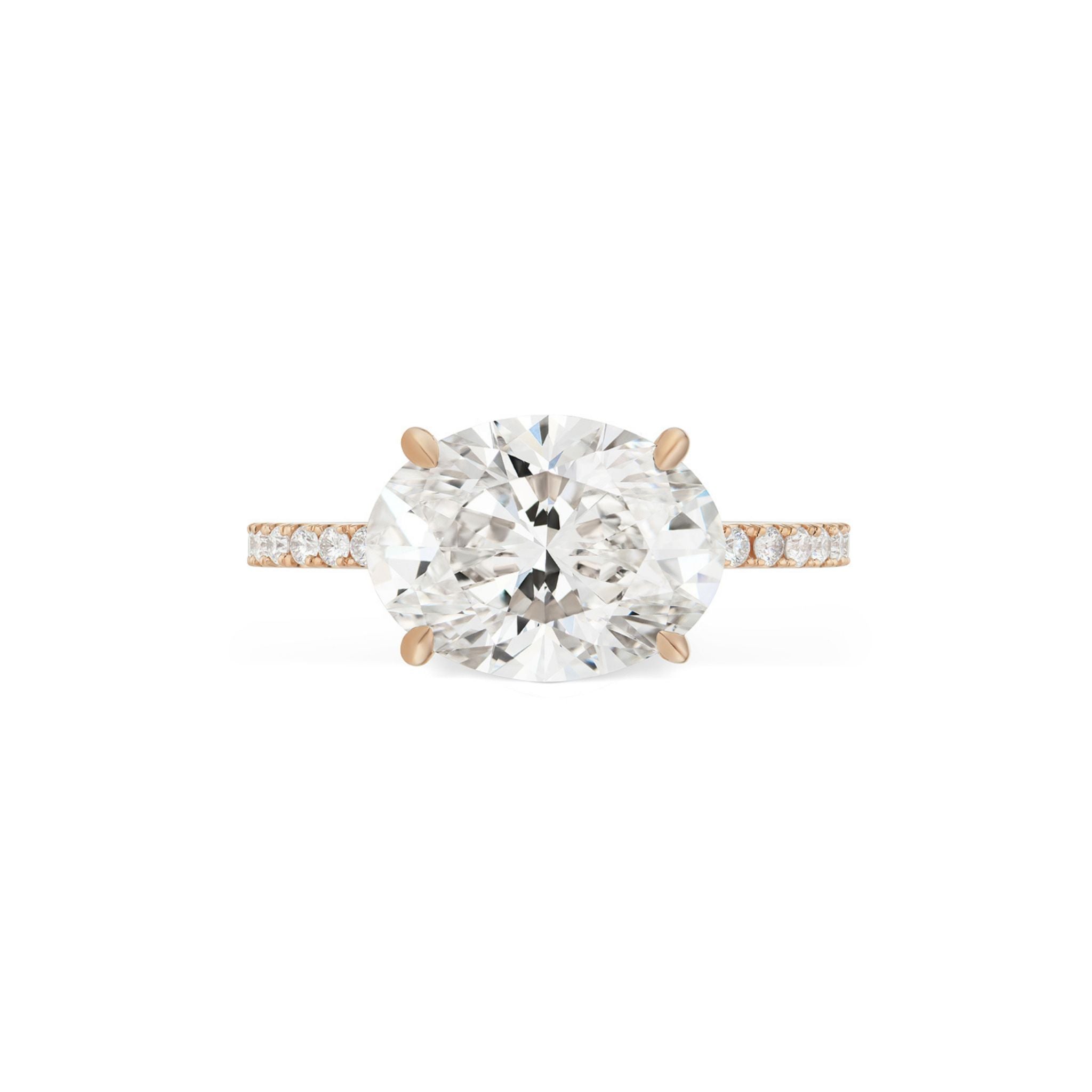 The East-West Oval Diamond Engagement Ring with Pavé Band features a striking oval-cut diamond set horizontally on a rose gold band adorned with pavé-set smaller diamonds, displayed against a white background.