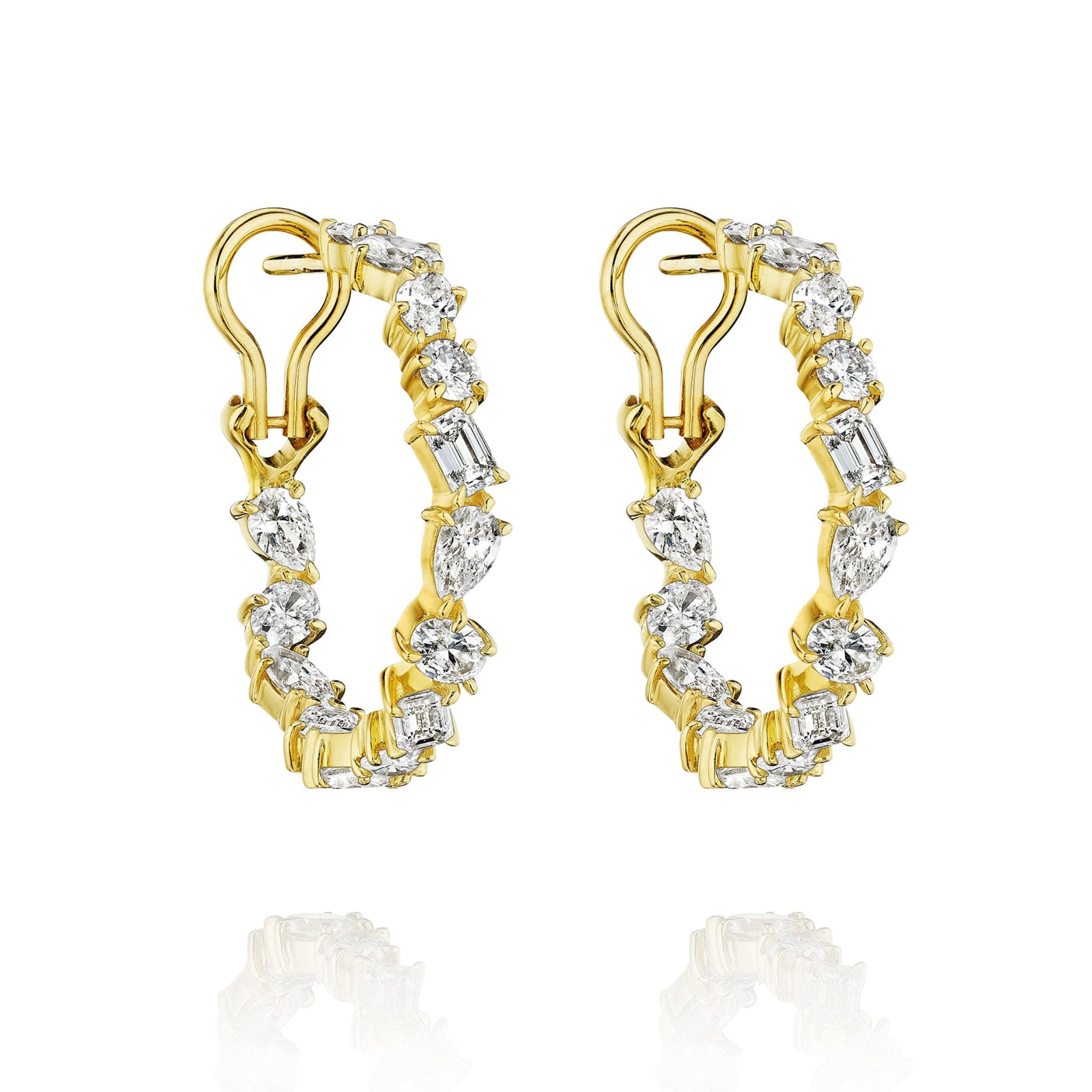 Mixed Shape Diamond Hoops in 18K lever back style feature alternating round, oval, and rectangular diamonds. Shown on a white background with subtle reflections below each earring.