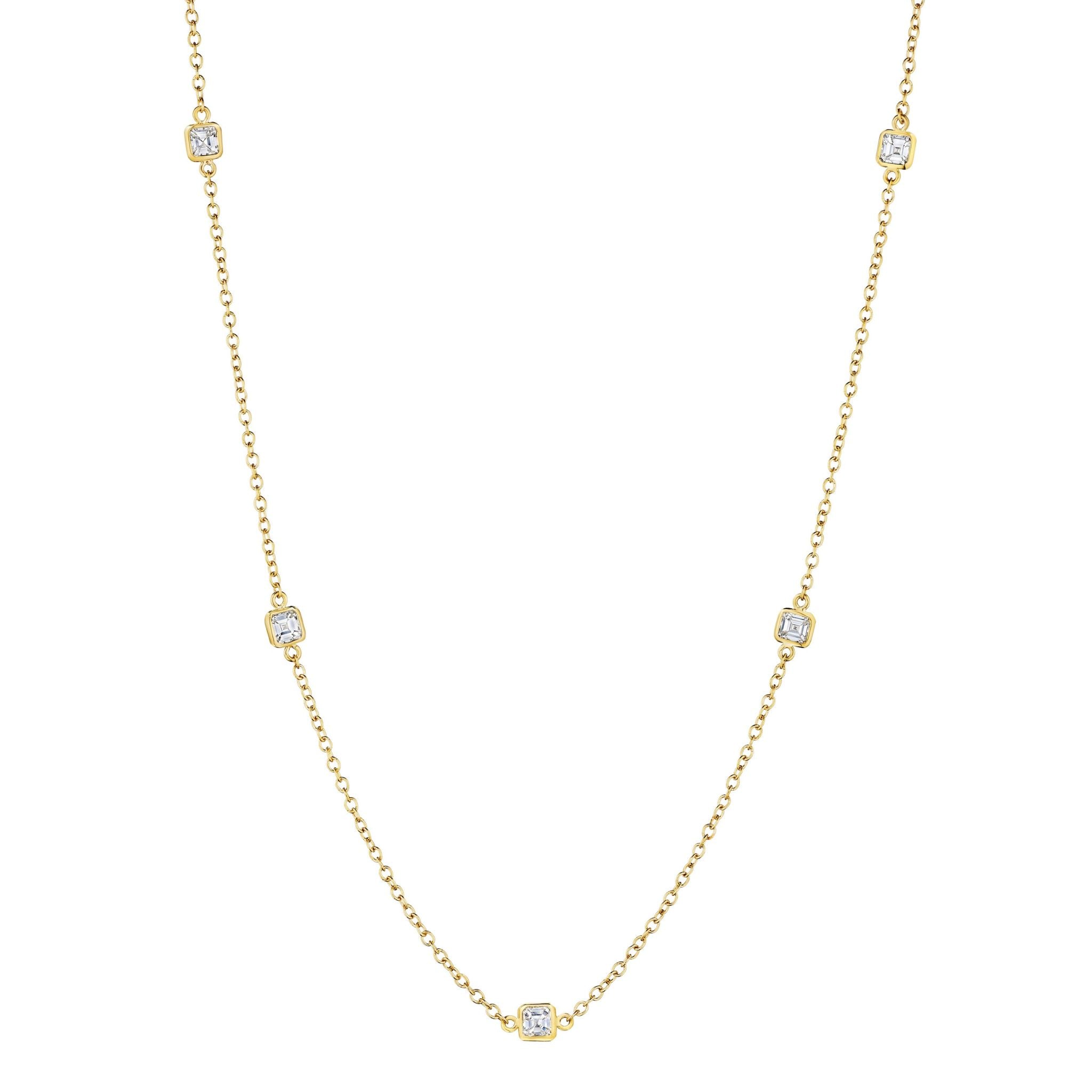 The Bezel Set Asscher Cut Station Necklace in Yellow Gold features five evenly spaced Asscher-cut diamonds, each bezel set on a delicate gold chain for a simple, elegant, and minimalistic look.