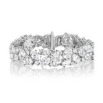 The Cluster Diamond Evening Bracelet showcases sparkling diamond clusters set in an 18k white gold band, beautifully displayed against a white background.