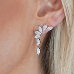 Close-up of a woman's ear wearing Climbing Ivy Waterfall Earrings in white gold, featuring marquise diamonds arranged like leaves. Light blonde hair and smooth skin provide a soft background.