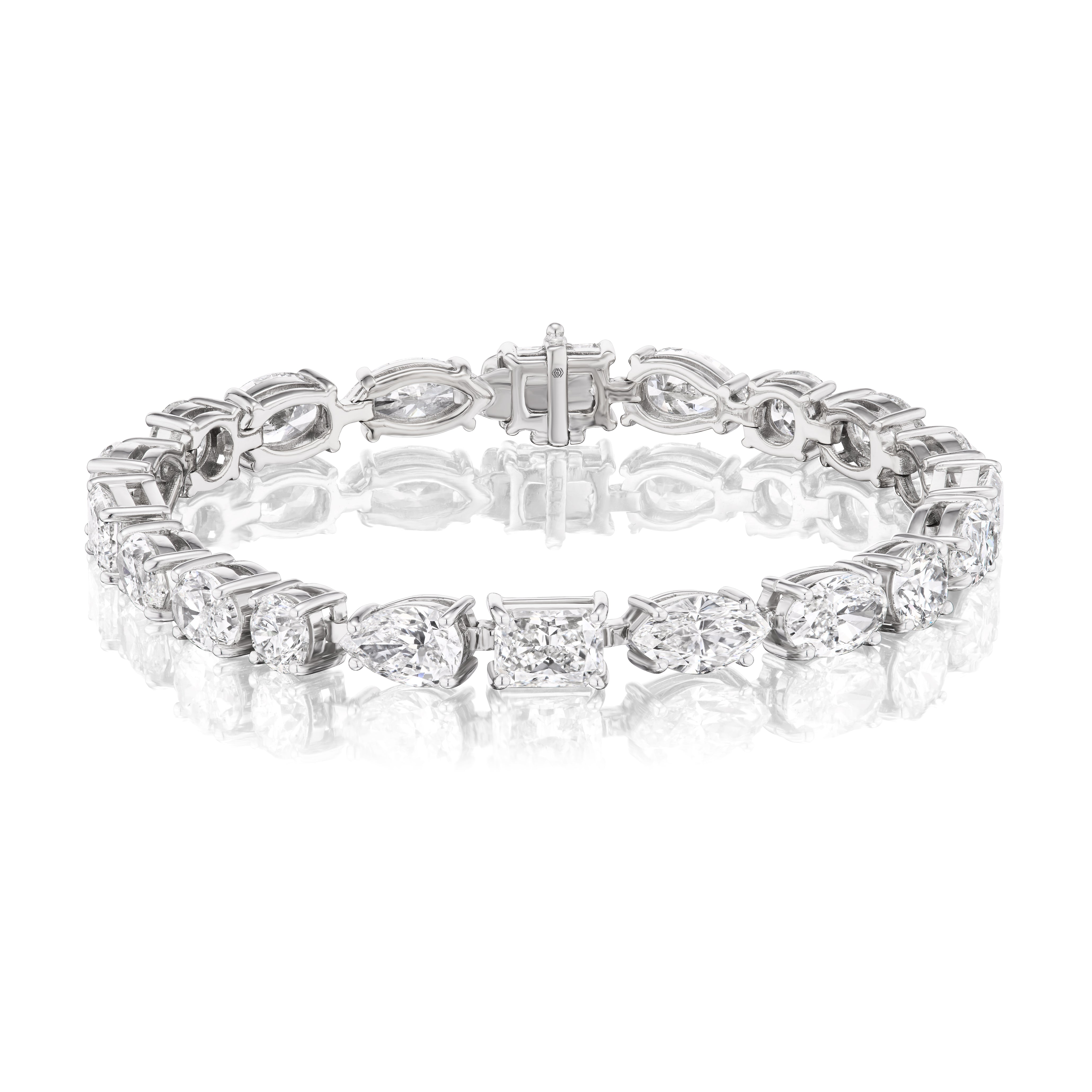 The Large East-West Mixed Shape Diamond Tennis Bracelet in 18k white gold showcases sparkling, alternating diamonds set in a unique pattern with a secure clasp, beautifully displayed against a white background.