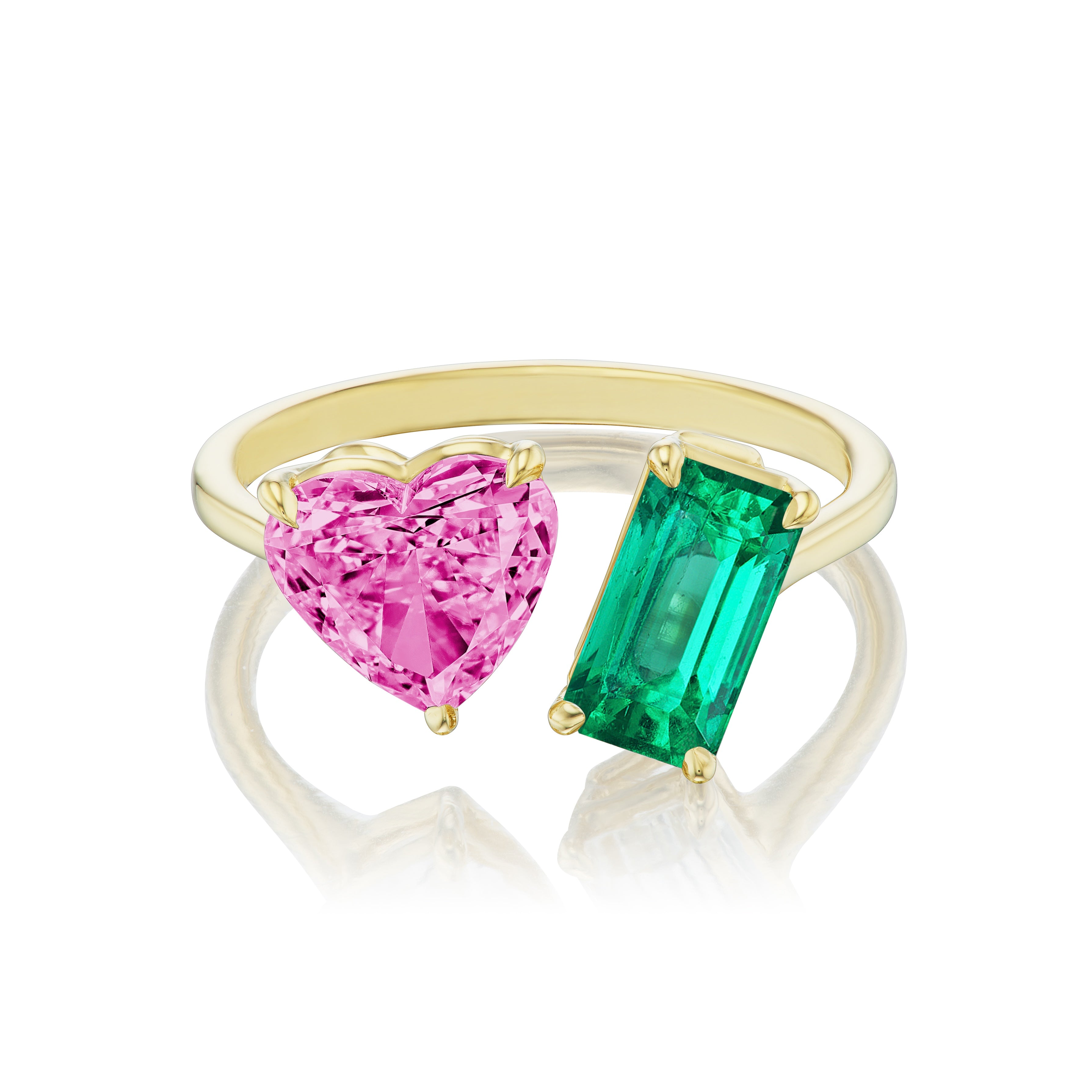 The Toi et Moi Ring features a pink heart sapphire and an emerald cut emerald set side by side in an open-band 18K yellow gold design.