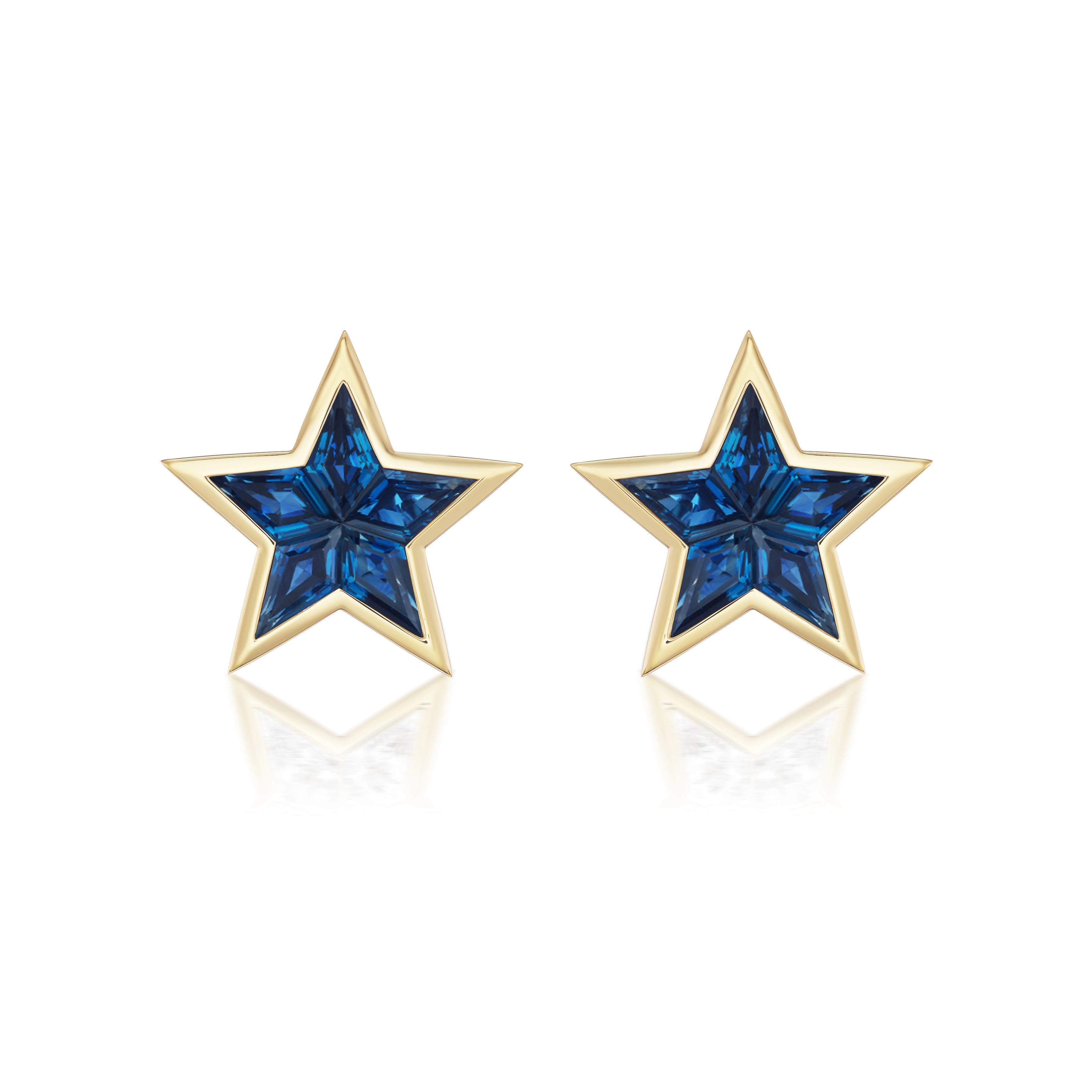 Bezel Set Star Studs in Yellow Gold with Kite Shape Blue Sapphires, crafted from 18K yellow gold and set with deep blue sapphires, add a stunning touch to any Blue Sapphire Jewelry collection. Shown on a white background with a subtle reflection.