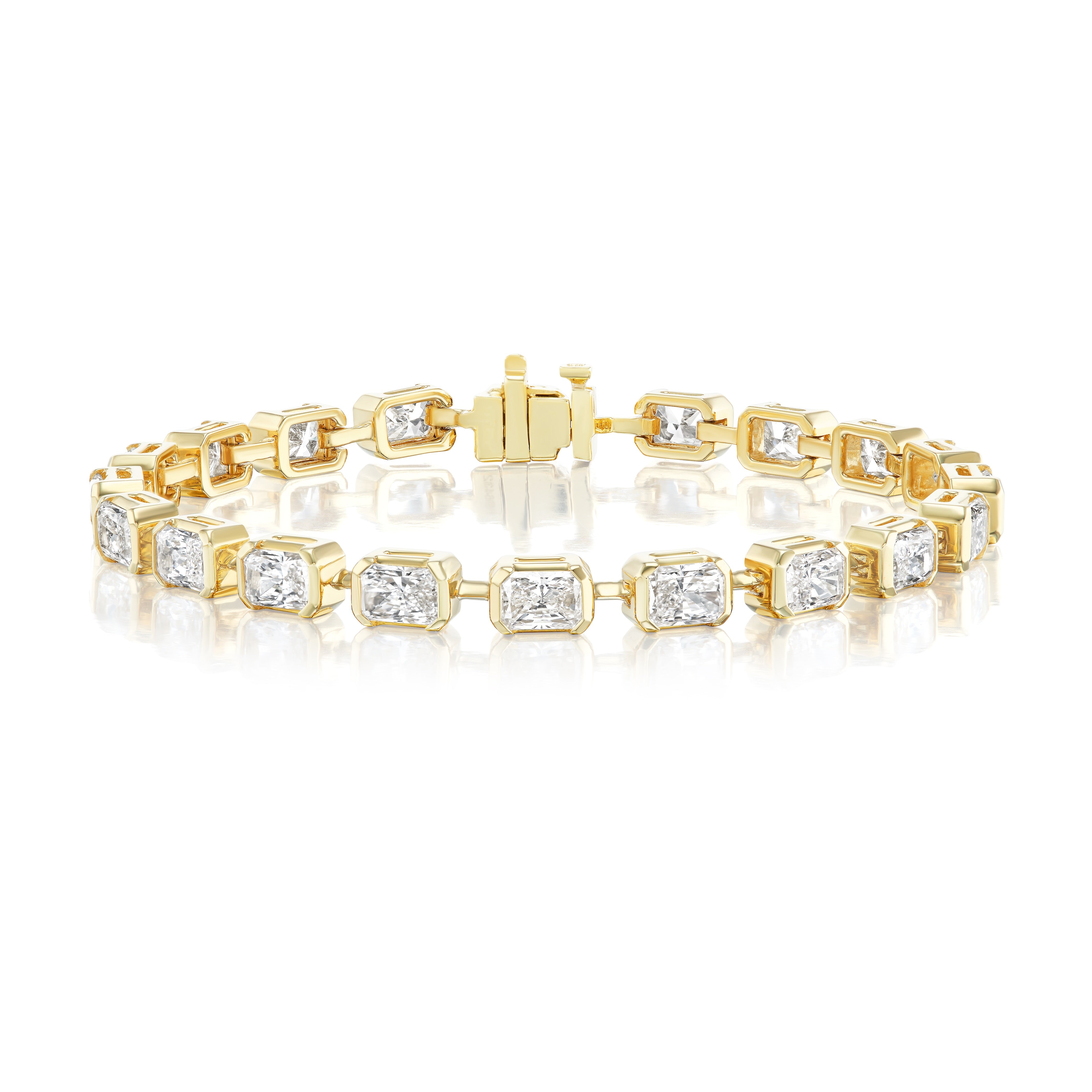 The East-West Half Bezel Set Radiant Cut Diamond Tennis Bracelet in Yellow Gold features sparkling VS2 clarity gemstones set in rectangular links, shown on a white reflective surface.