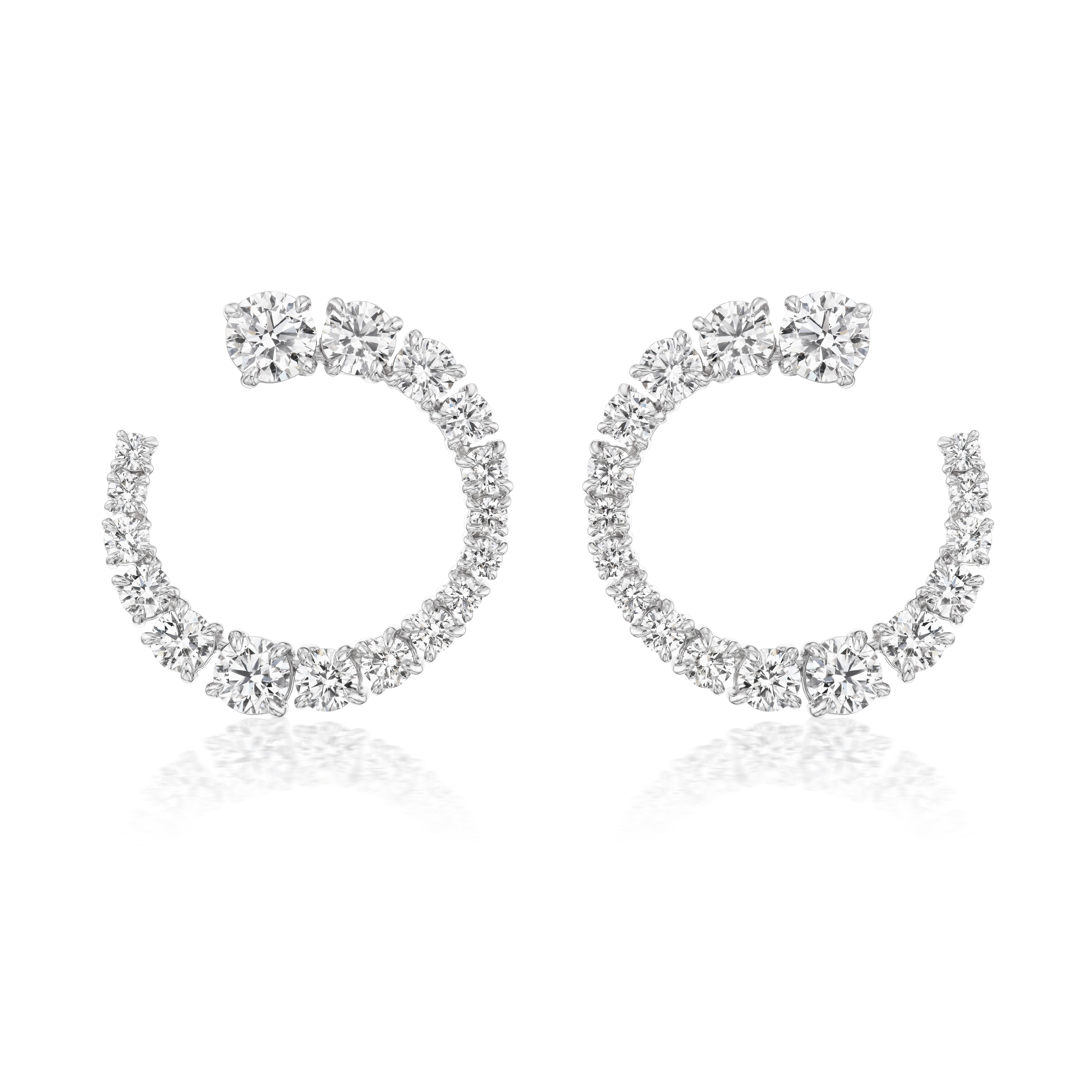 Introducing the Wave Round Diamond Front to Back Hoops in White Gold—open hoop earrings adorned with graduated round diamonds, crafted in 18k white gold and showcased against a white background.