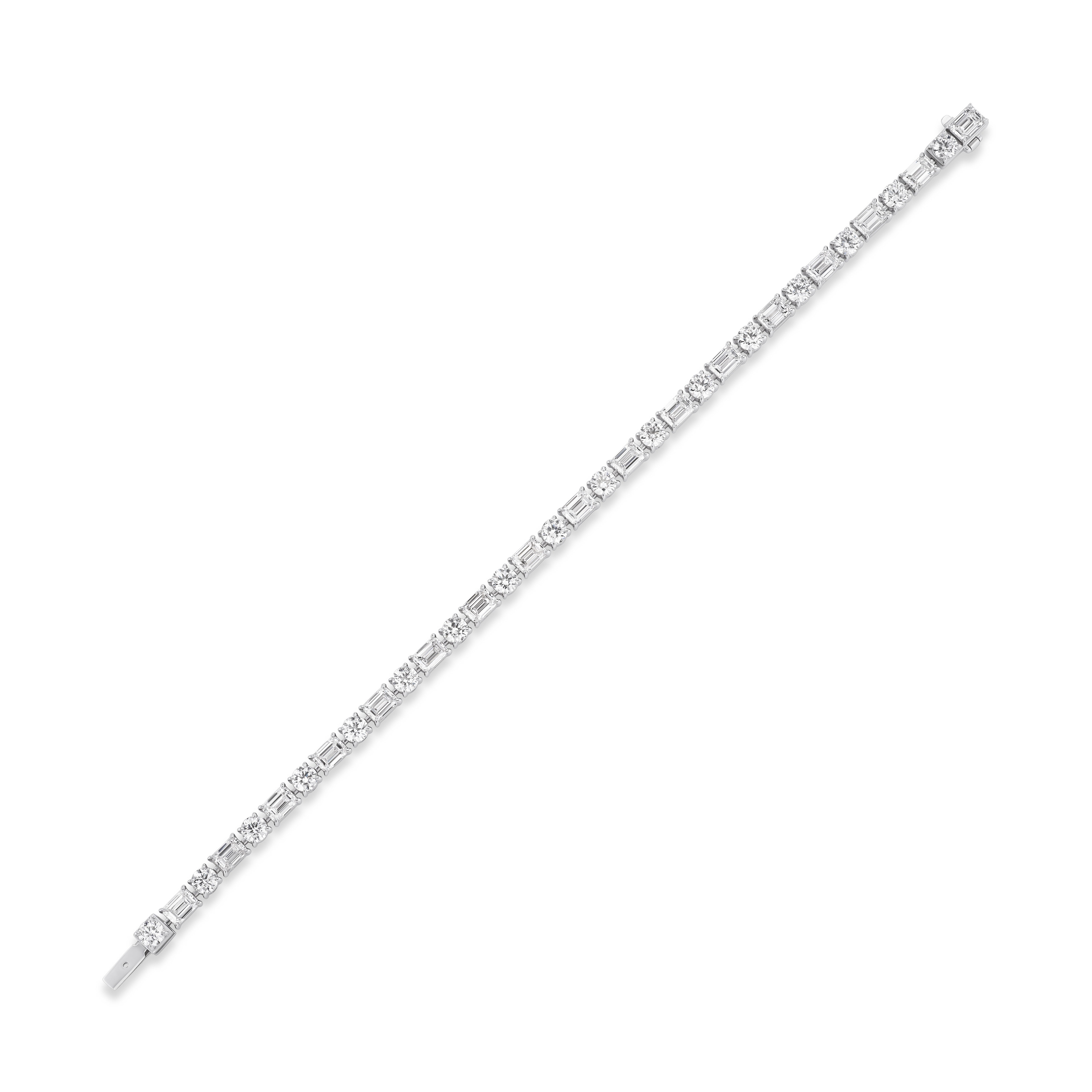 An Alternating East-West Set Round and Emerald Cut Diamond Tennis Bracelet in white gold, featuring sparkling diamonds set in a unique east-west pattern, elegantly displayed diagonally on a white background.