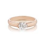 The East-West Pear Diamond Solitaire Band features a modern, wide rose gold setting with a single pear diamond, shown on a white background.