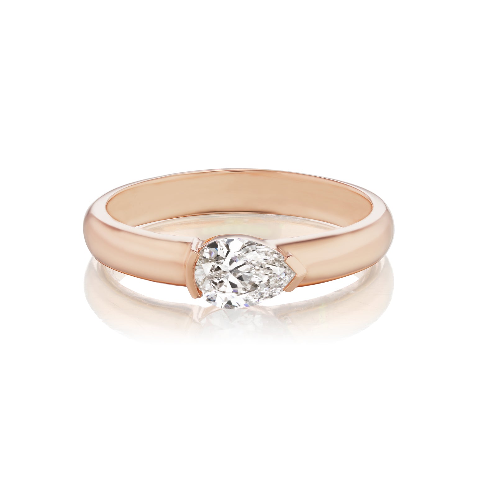 The East-West Pear Diamond Solitaire Band features a modern, wide rose gold setting with a single pear diamond, shown on a white background.