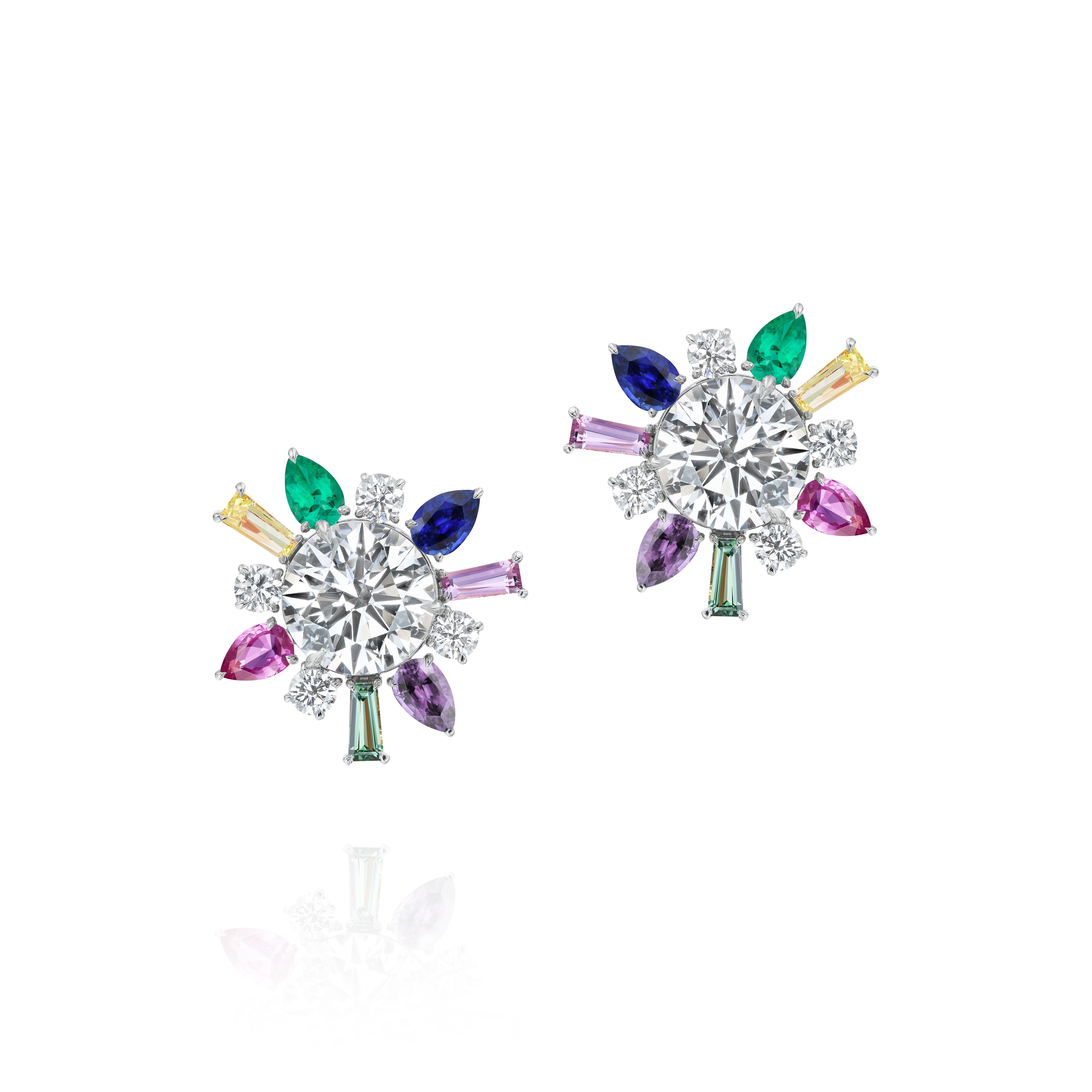The Confetti Multicolor Ear Jackets in White Gold feature large central round diamonds, accented by marquise, baguette, and round sapphires in green, blue, yellow, purple, and pink arranged in a floral design.