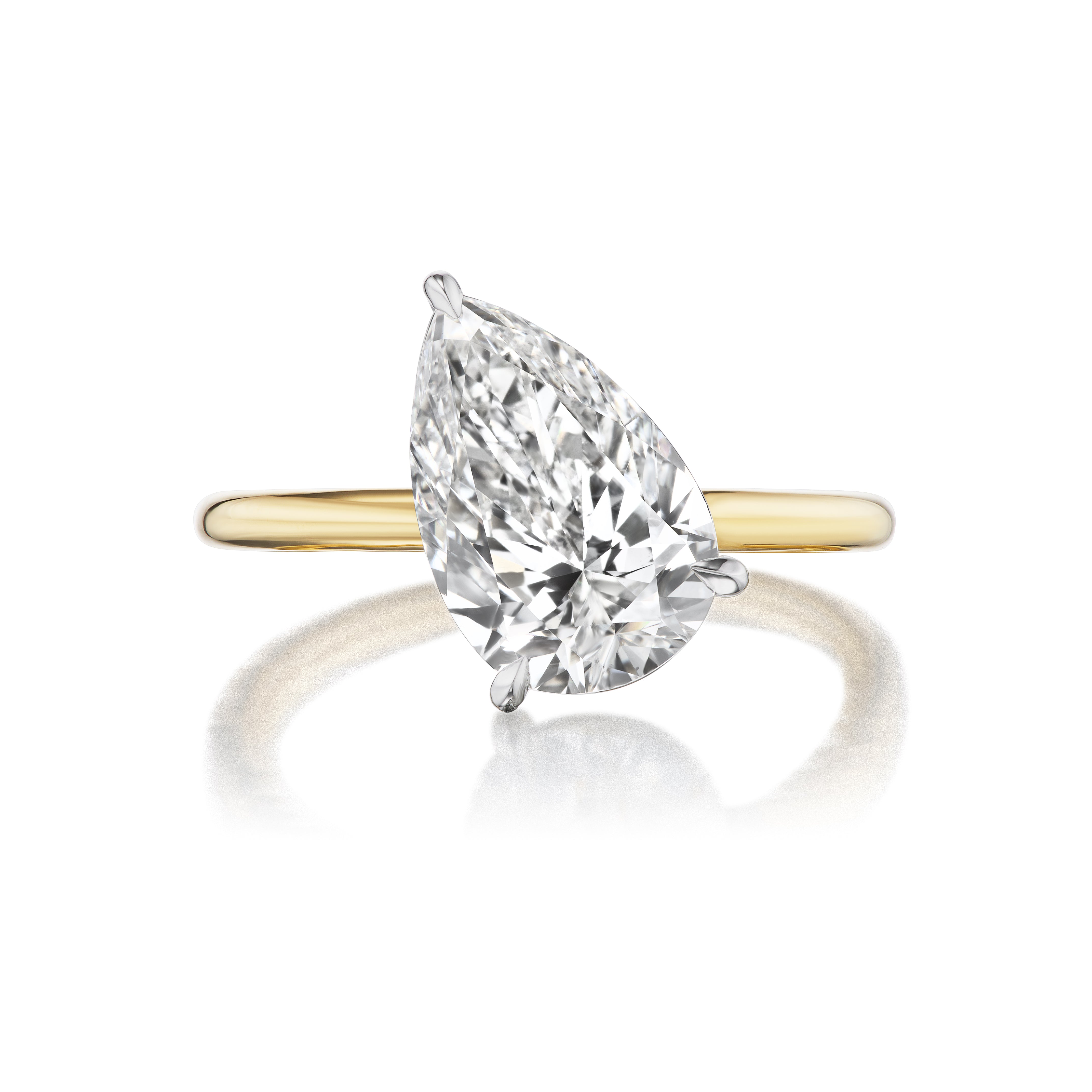 The Diagonally Set Pear Shape Diamond Engagement Ring features a large pear-shaped diamond solitaire in a sleek 18K yellow gold prong setting, shown on a white background.