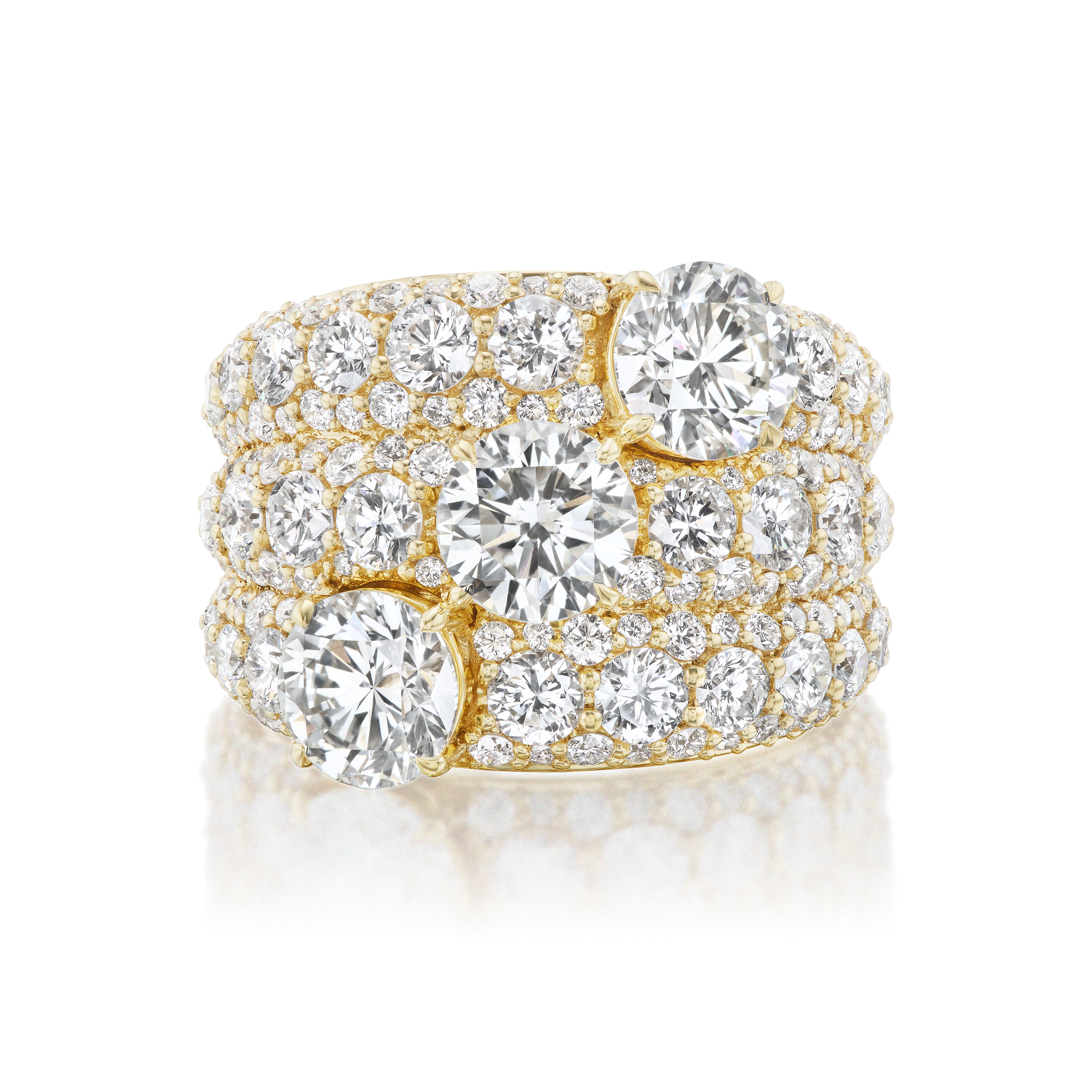 Experience elegance with the Three Stone Round Diamond Cocktail Ring in Yellow Gold, featuring three stunning round center diamonds accented by sparkling rows of smaller diamonds.