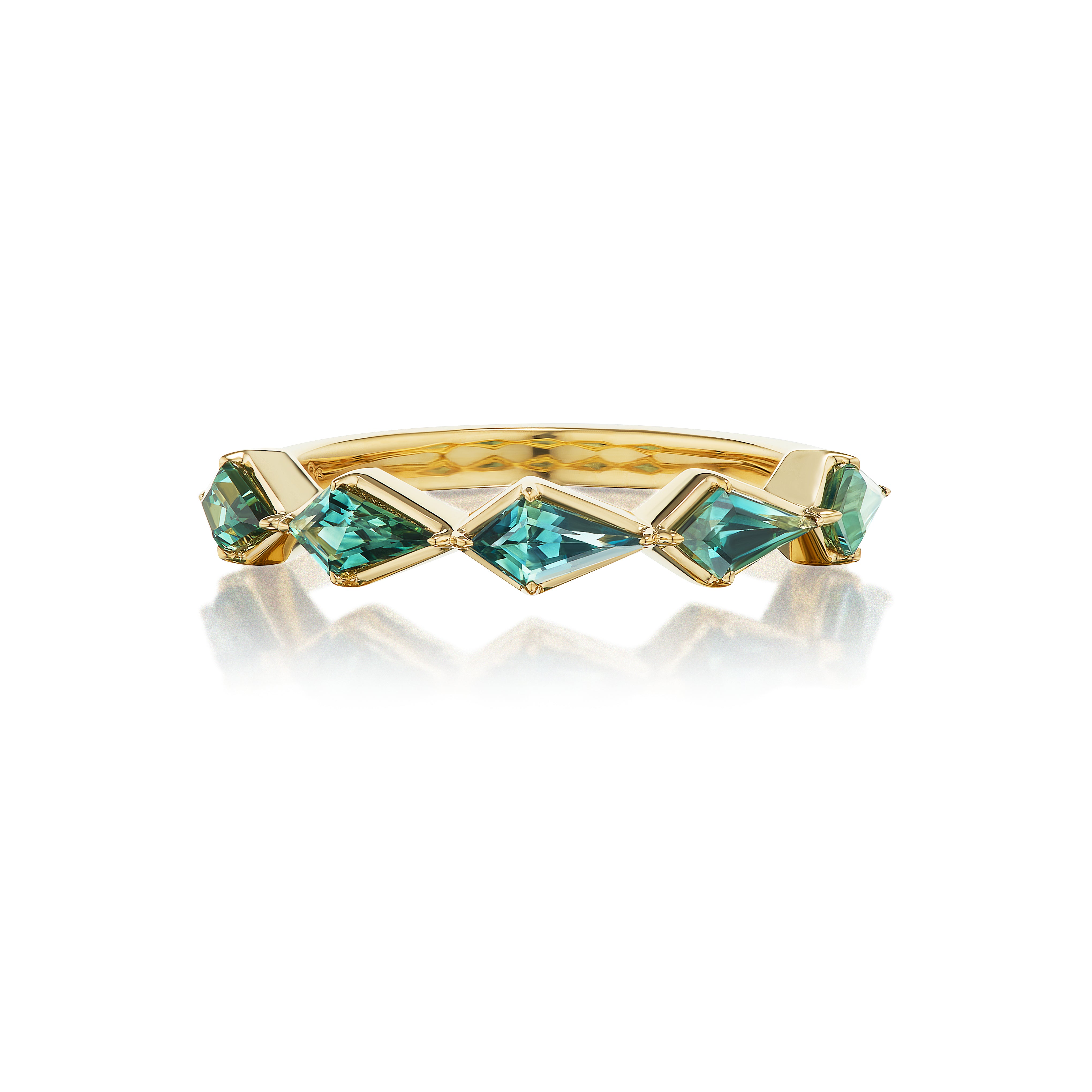 The Chasing Kites Emerald Half Eternity Band in Yellow Gold showcases five blue-green, kite-shaped emeralds set in 18K yellow gold, each with an angular, faceted cut and displayed on a white reflective surface.