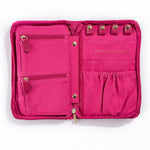 The Serpentine Travel Case is a bright pink vegan leather jewelry organizer with two zippered left pockets, four snap loops and two gathered right pouches, plus gold "Serpentine Jewels" text.