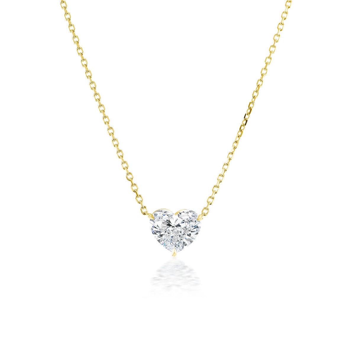 The Heart Diamond Solitaire Pendant is a delicate 18k gold necklace with a sparkling heart-shaped diamond at the center, shown on a white background.