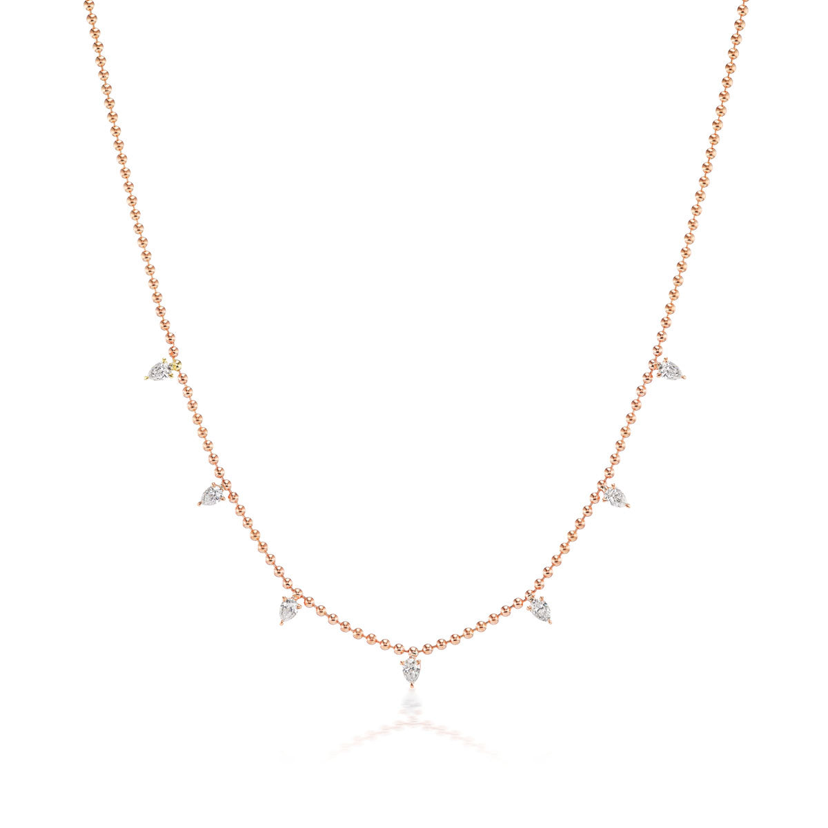 The Spike Ball Chain Necklace with Pear Diamonds features small, pear-shaped diamonds spaced along a delicate 18K gold chain, displayed on a white background.
