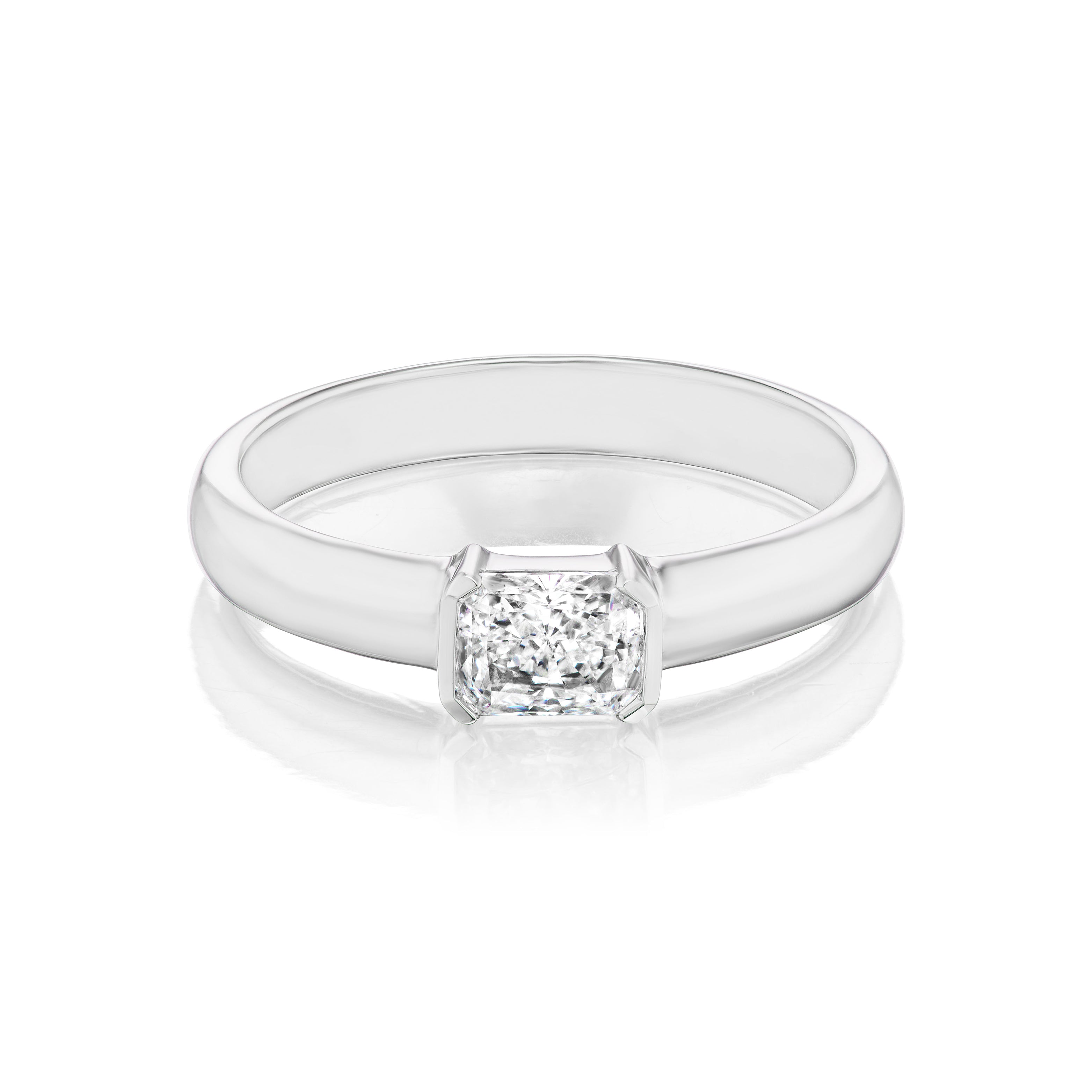 The East-West Radiant Cut Diamond Solitaire Band features a sleek 18K white gold band and a square radiant-cut diamond, set in a polished, minimalist style against a crisp white background.