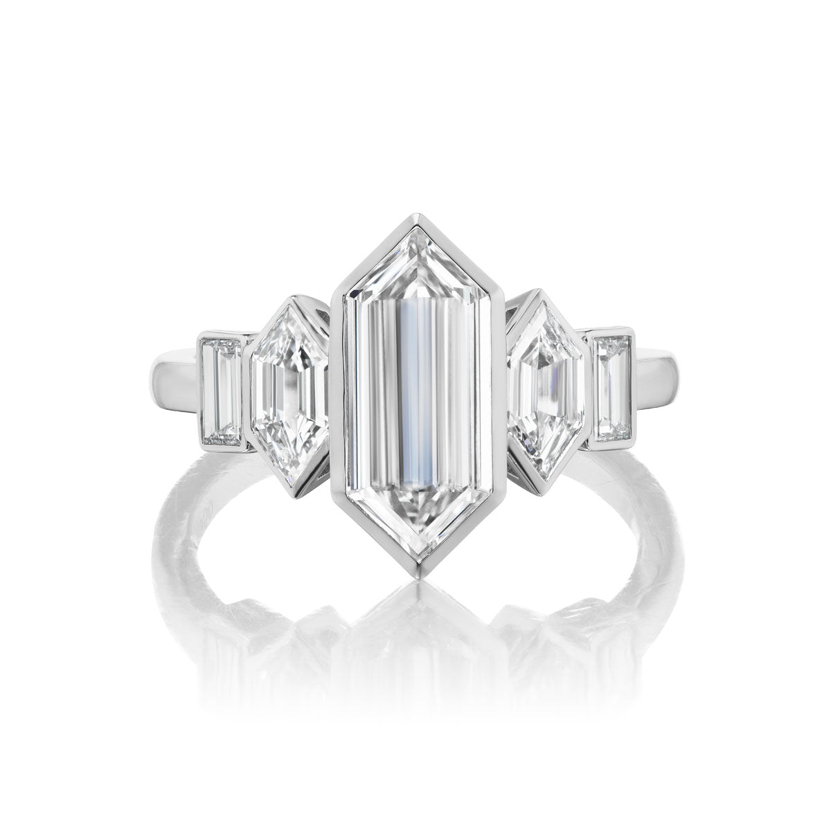 The Elongated Hexagon Diamond Engagement Ring features a central hexagonal diamond with hexagon and baguette side stones, set on a polished white gold or platinum band for a bespoke design.