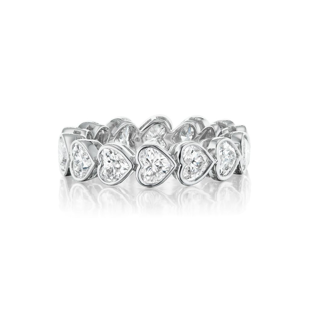 The Chasing Hearts Bezel Set Eternity Band in 18k white gold features VS1-VS2 diamonds, each set in a silver heart-shaped bezel, displayed on a white background.