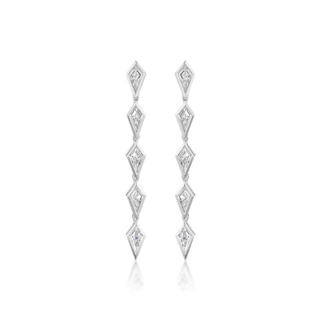 The Chasing Kites Drop Earrings in white gold feature a vertical row of bezel set kite diamonds, each segment adorned with a small clear gemstone, shown on a white background.