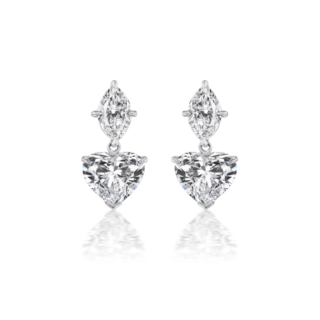 The Heart Diamond Drop Earrings showcase a marquise-cut diamond above a larger heart-shaped diamond, both set in radiant 18K white gold for a beautifully reflective look.