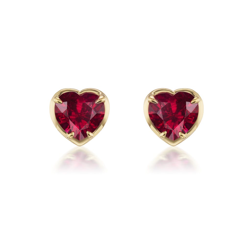 The Ruby Heart Studs in Yellow Gold feature heart-shaped rubies bezel set in 18K yellow gold, elegantly displayed on a white background.
