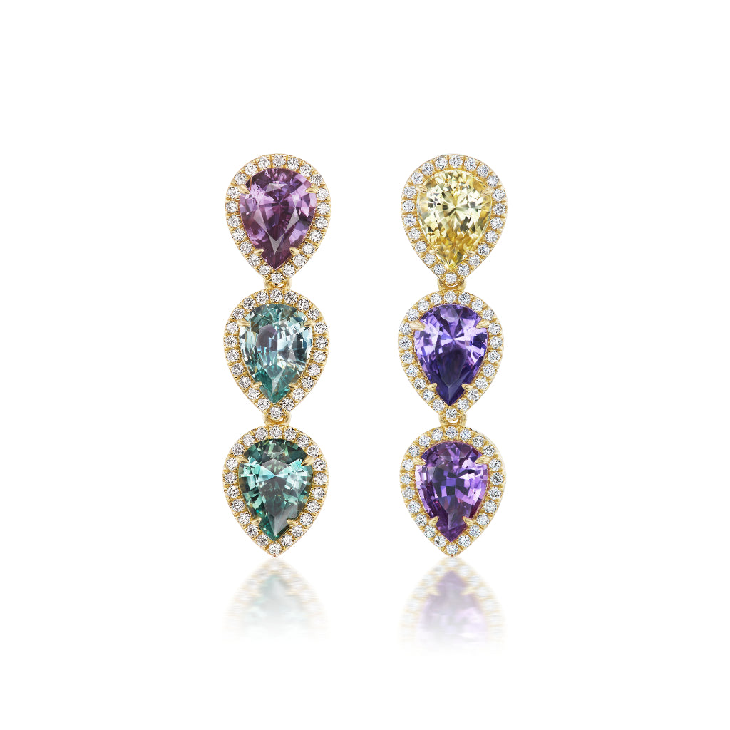 The This & That Pavé Drop Earrings with Multicolor Pear Sapphires in 18K yellow gold feature triple drops of pear-shaped sapphires—yellow, purple, blue, green—haloed by white diamonds, shown against a white background.