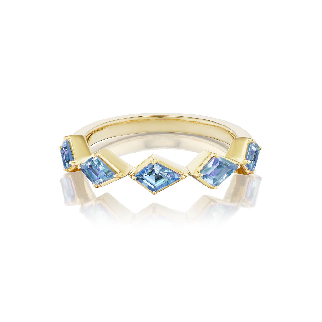 The Chasing Kites Light Blue Sapphire Half Eternity Band, crafted in 18K yellow gold with five square-cut blue sapphires in a zigzag pattern, is shown on a white background with a subtle reflection below.