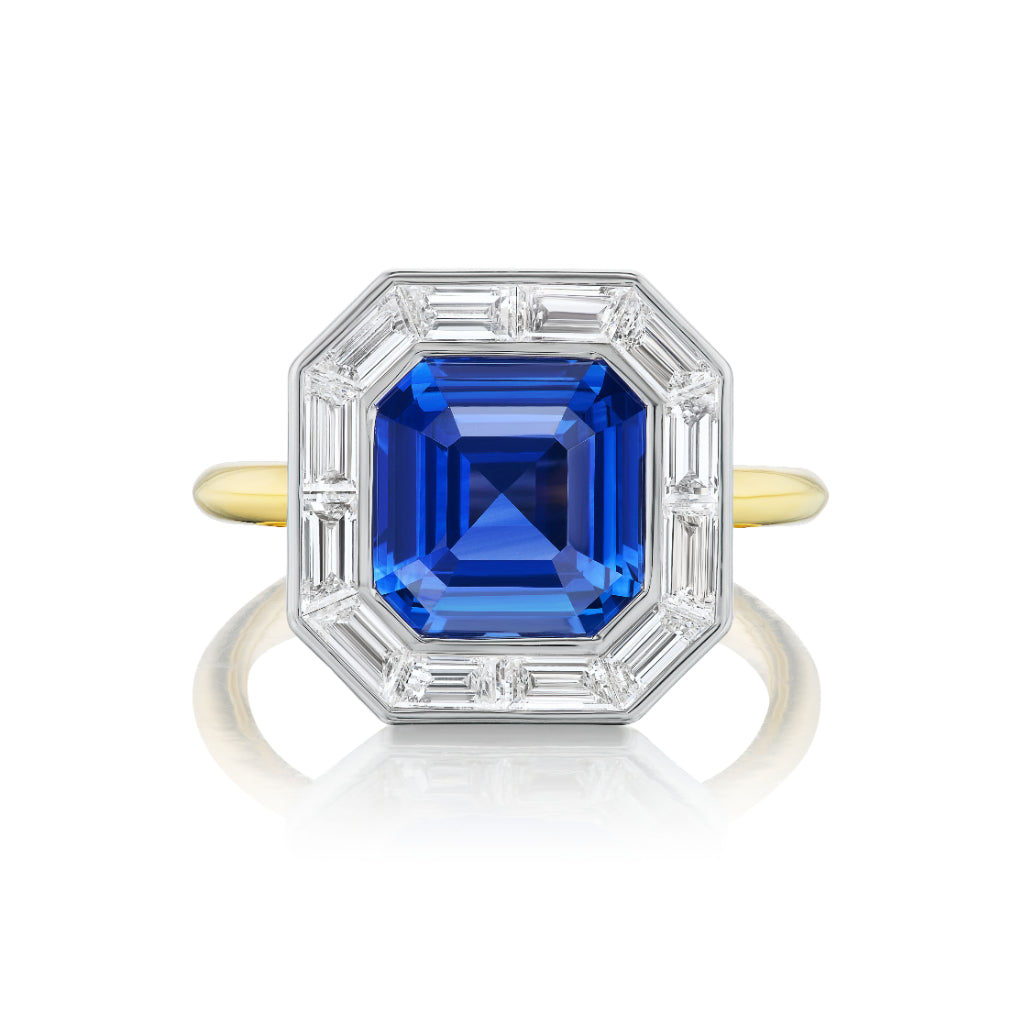 The Mosaic Ring features an Asscher cut blue sapphire set in 18K gold, accented with baguette diamonds in a bold octagonal geometric design.