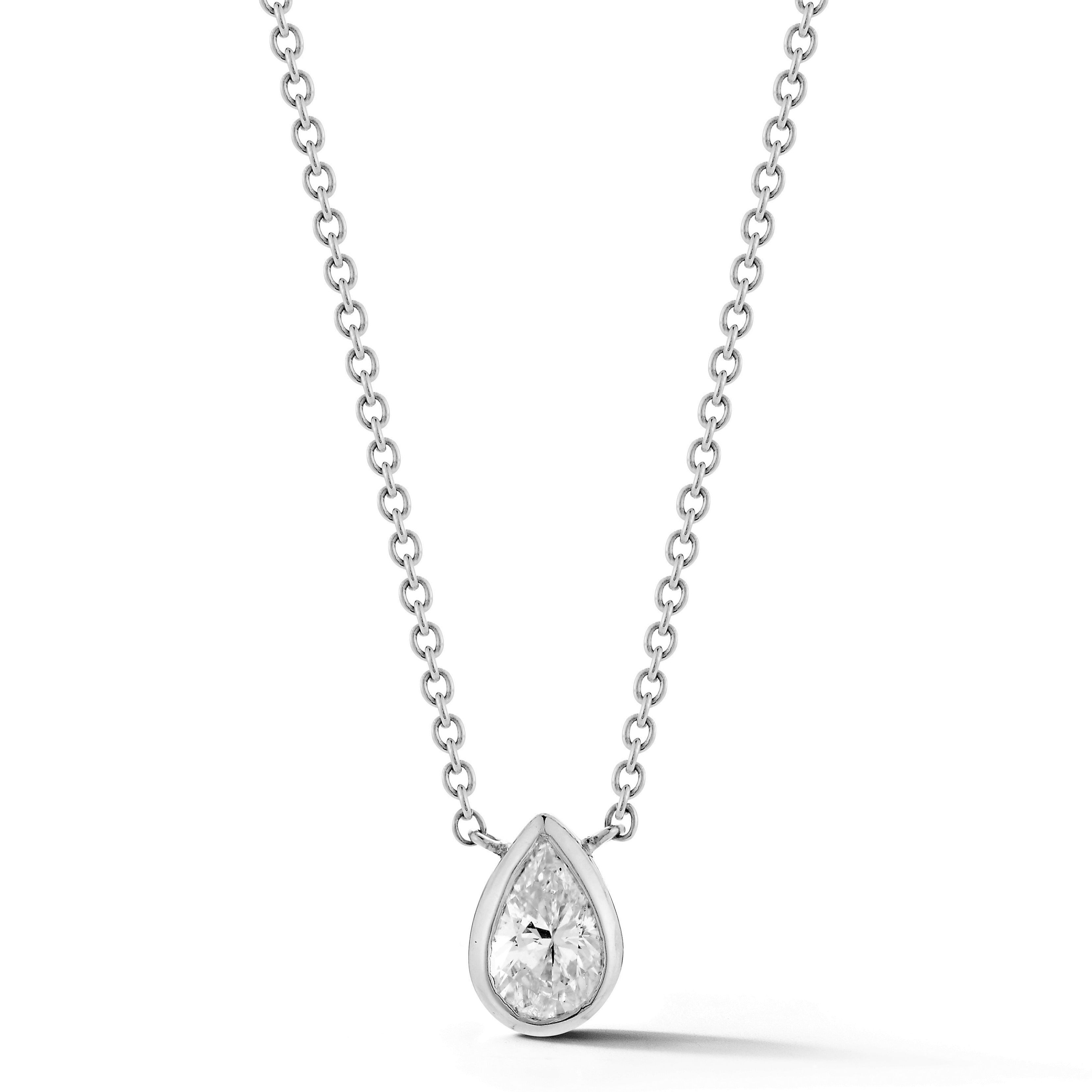 The Bezel Set Pear Diamond Solitaire Pendant in White Gold features a single shimmering pear diamond set in 18K white gold on a fine silver chain for an elegant look.