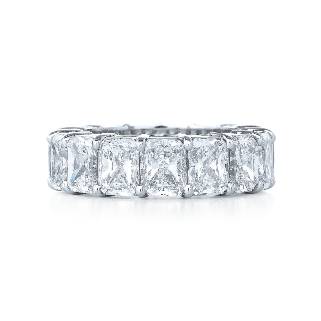 The Radiant Cut Diamond Eternity Band features a continuous row of large radiant cut diamonds in a platinum prong setting, elegantly displayed against a white background.