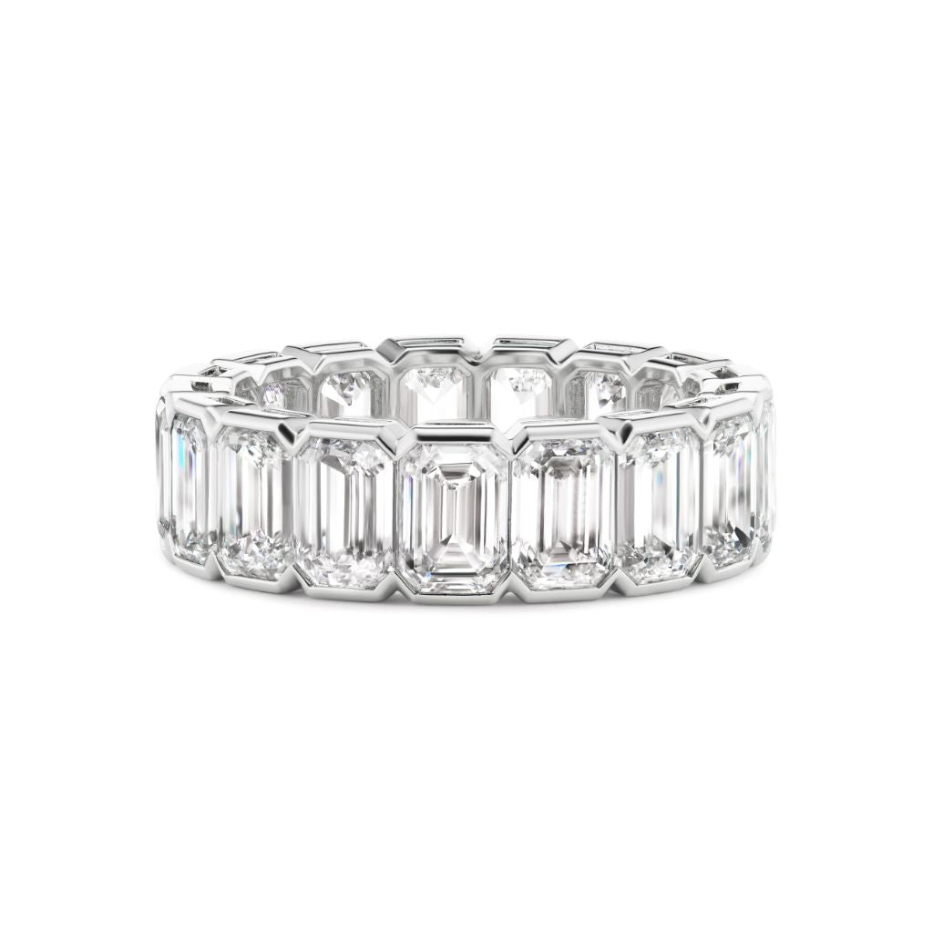 The Half Bezel Emerald Cut Diamond Eternity Band features large emerald-cut diamonds set in platinum, beautifully displayed on a white background.